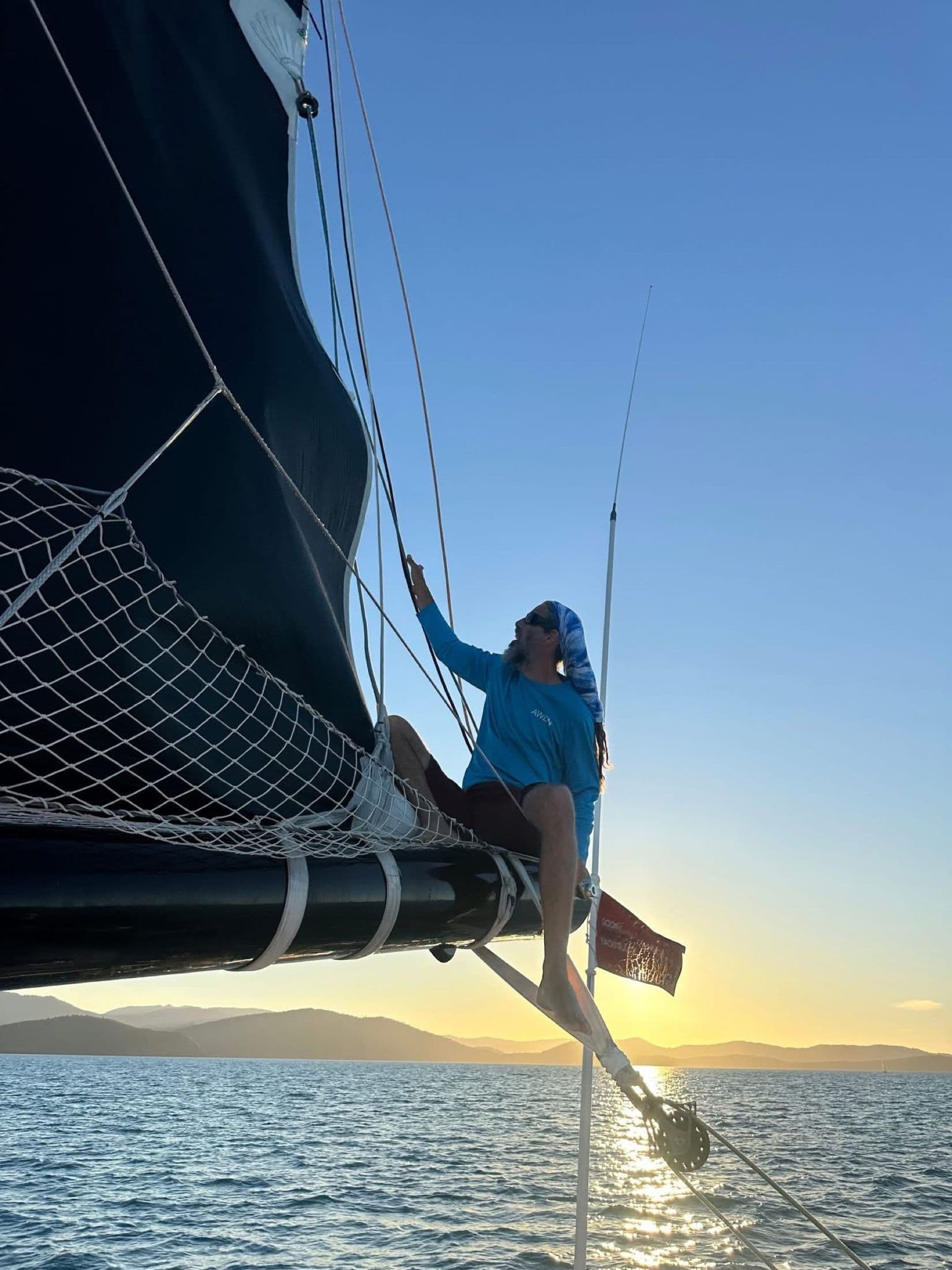 Franco sitting on the bow net at sunset